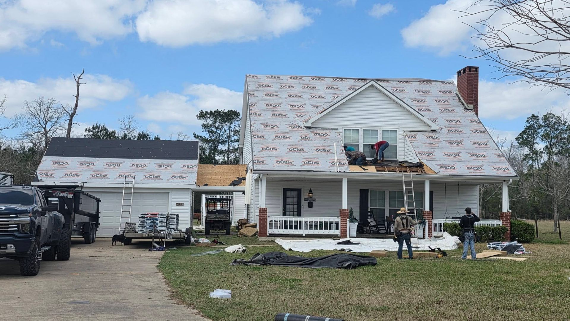 Crew installing new roof underlayment