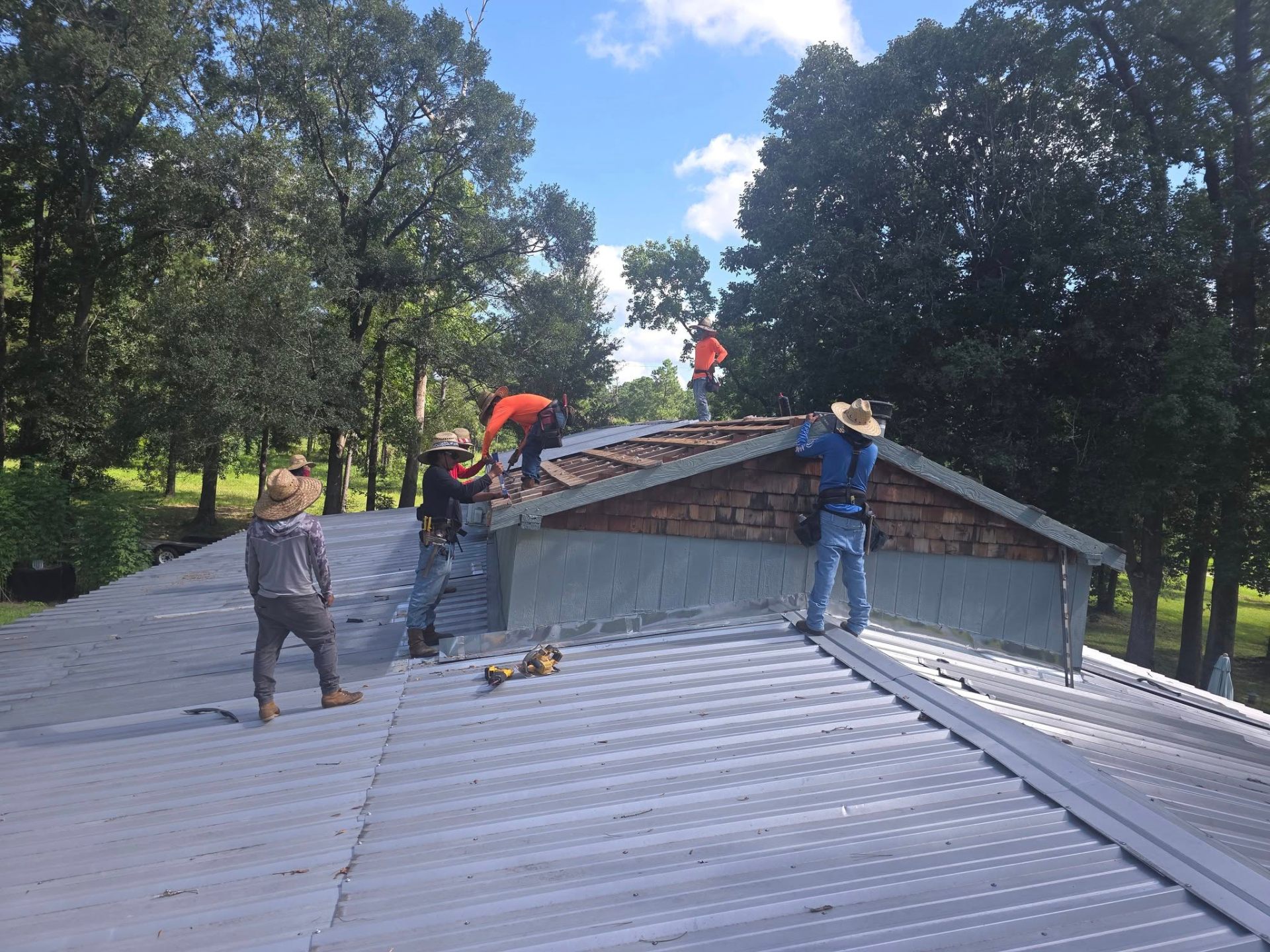 Crew working on metal and shingle roof